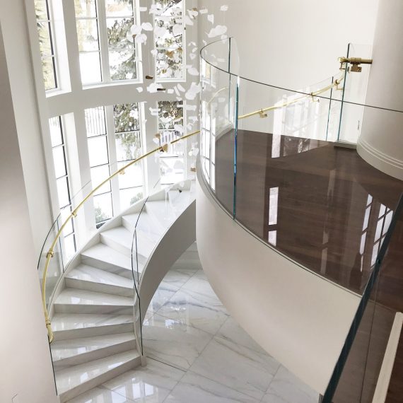 curved stairway with glass panel railing